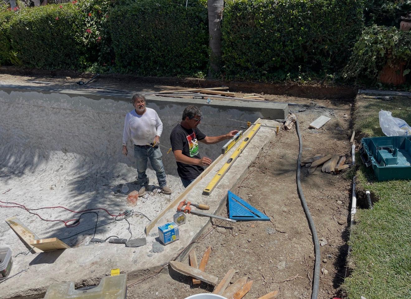 Team carefully leveling the pool edge