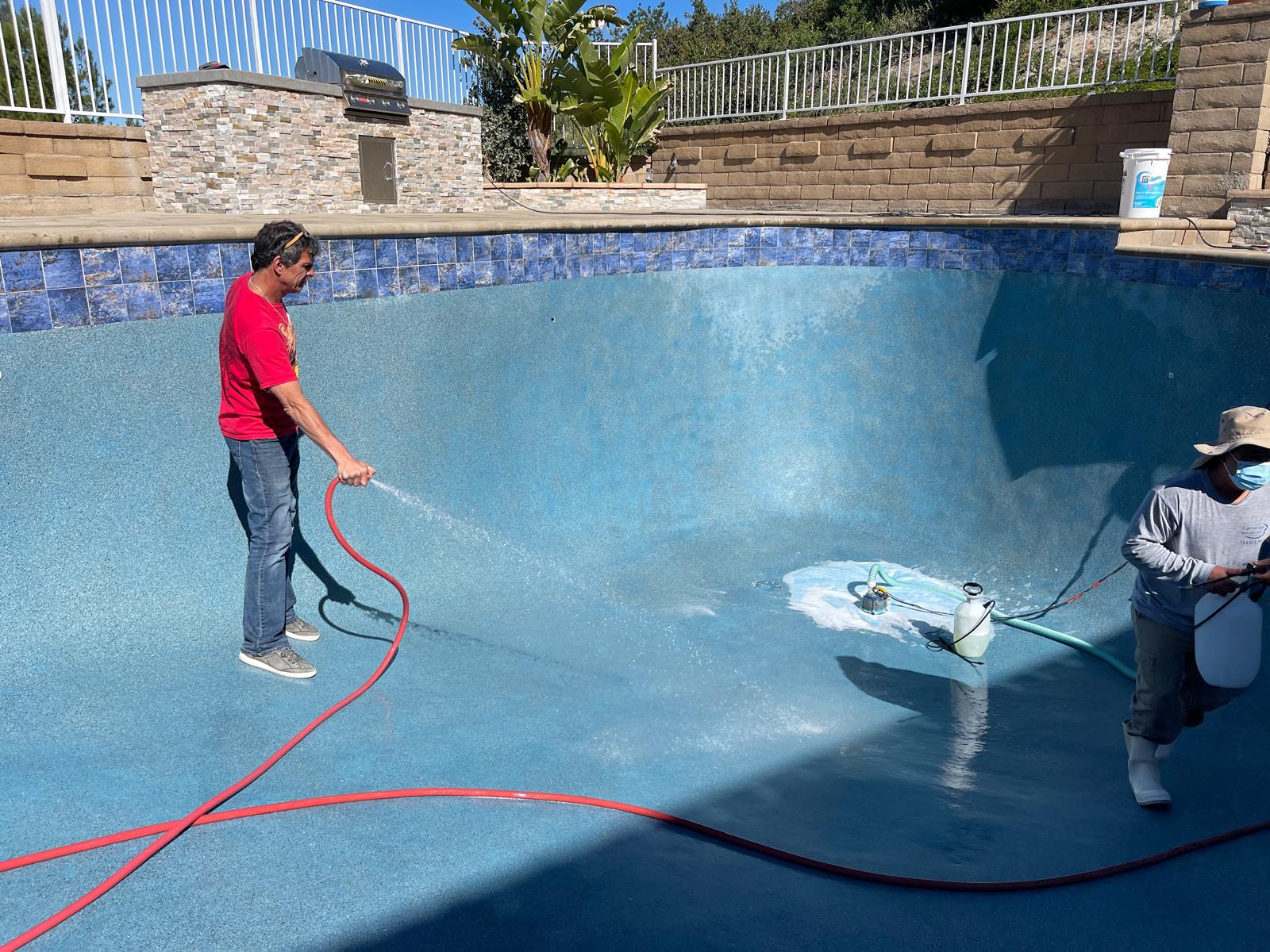 Roby rinsing a swimming pool during restoration